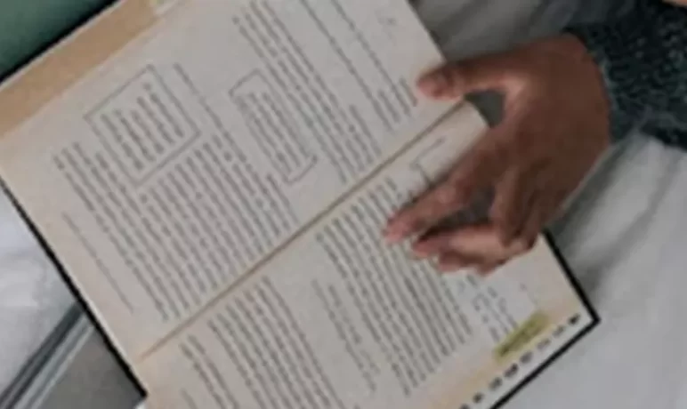 bovenaanzicht open geslagen boek met hand